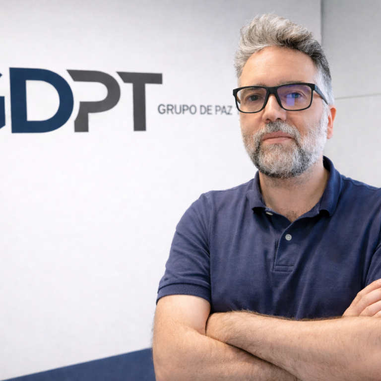 Hombre con gafas y barba, de brazos cruzados, junto al logo de GDPT.